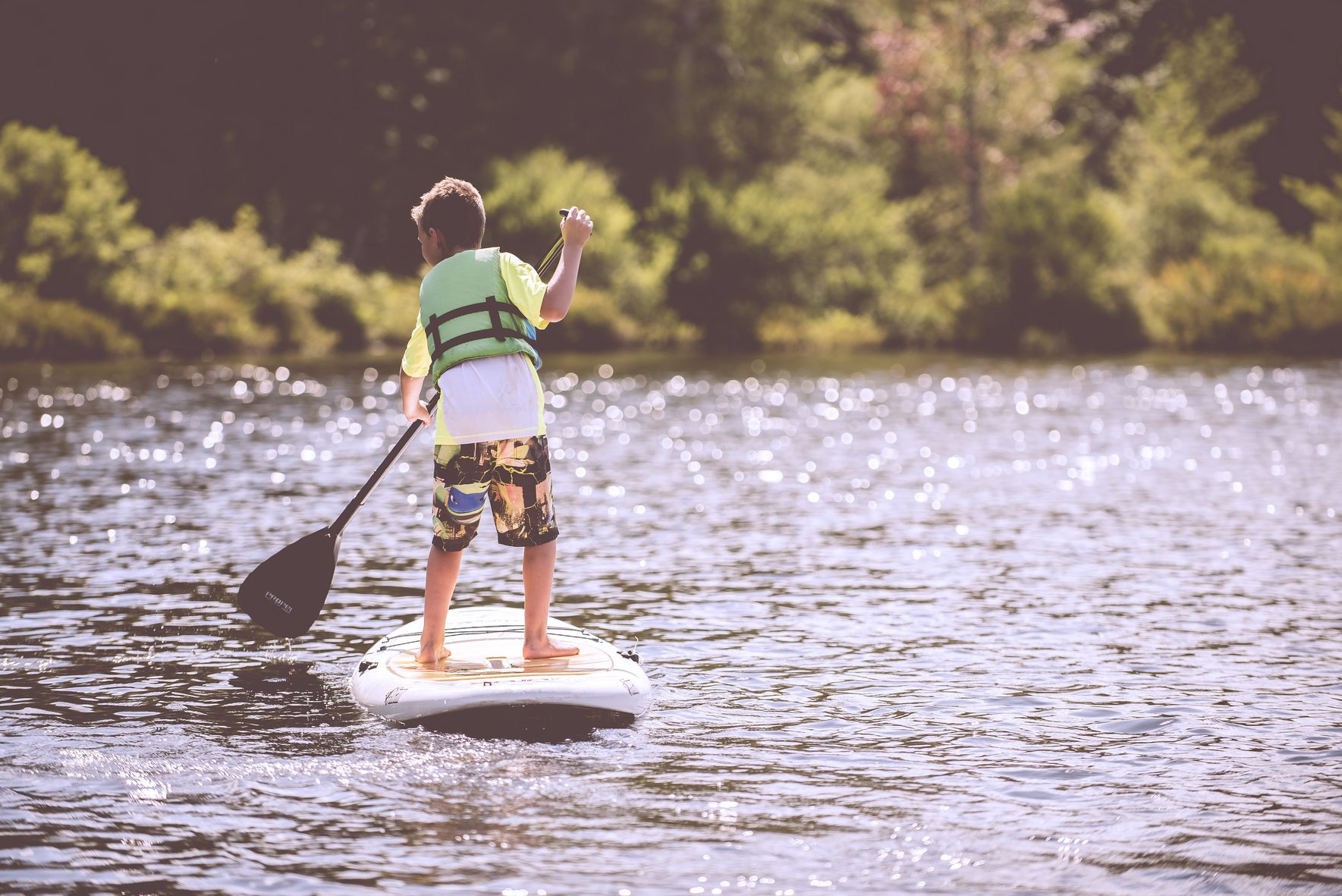 Boy Paddle Surfing in the Lake